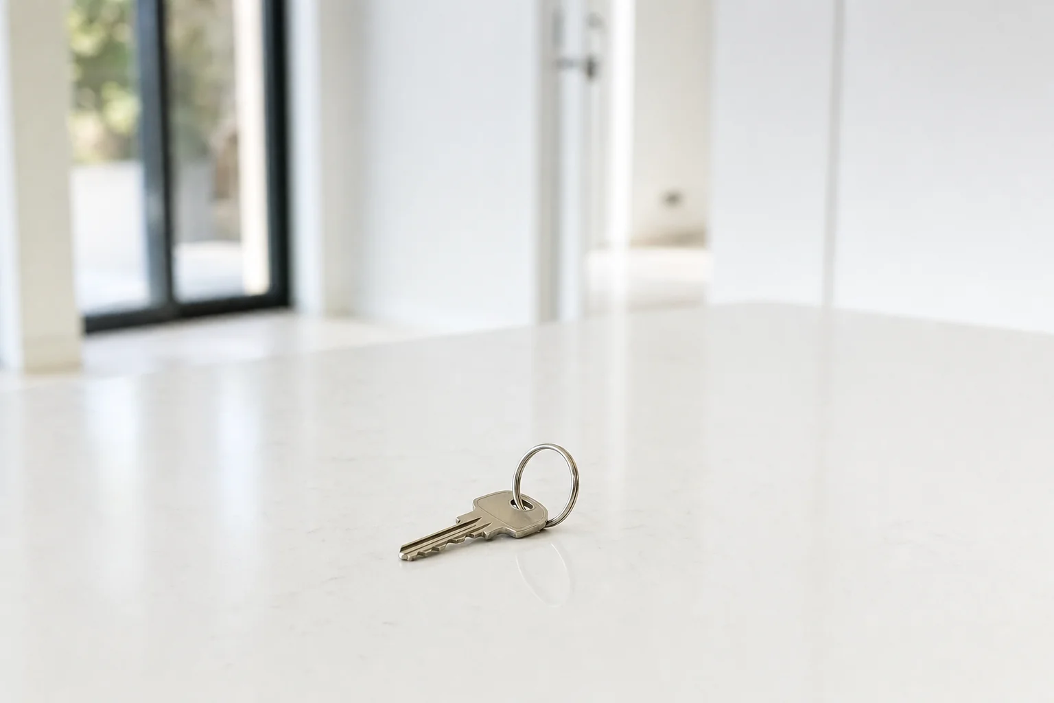House keys on a clean stone benchtop in an empty property